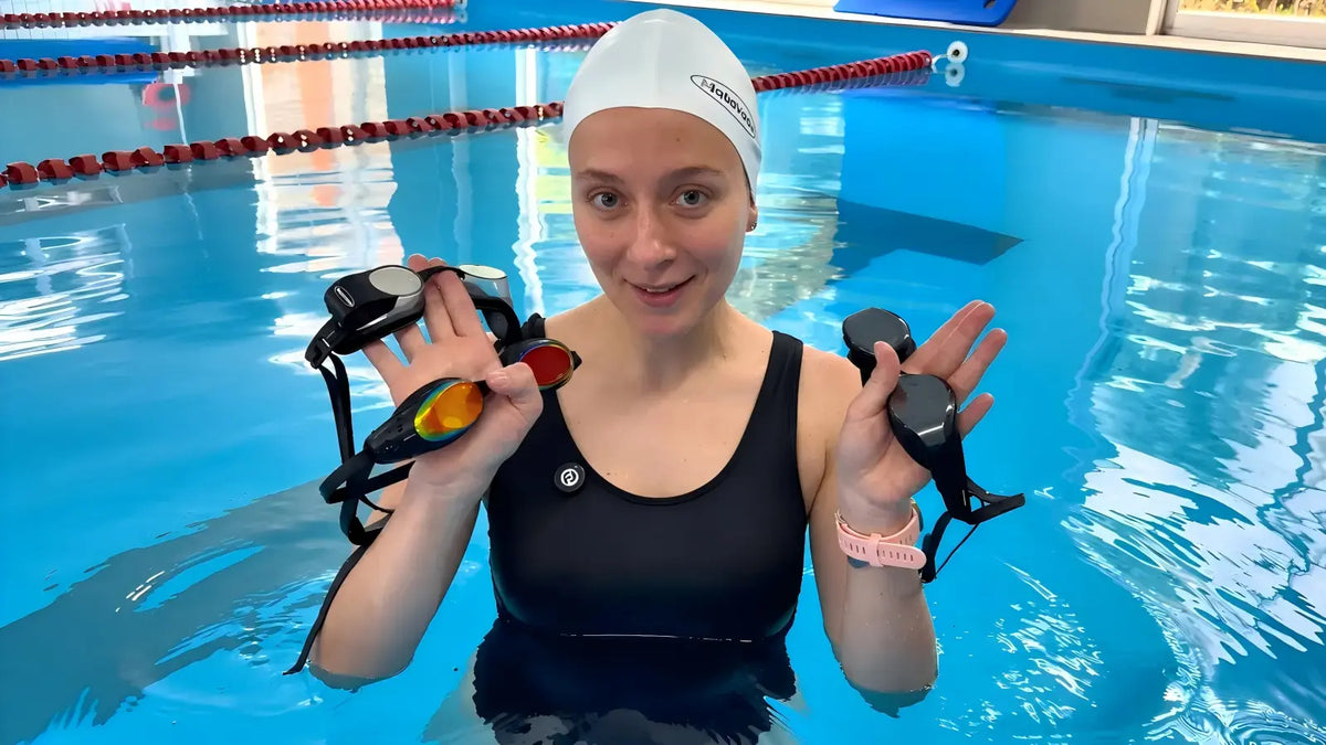 Bia holding HoloSwim 2 Pro, HoloSwim 3 Pro and SollaWave goggles in an indoor pool