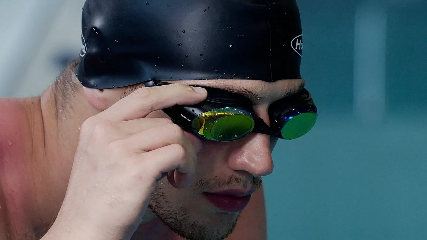 Close-up of male swimmer adjusting HoloSwim 3 Pro smart swim goggles before training