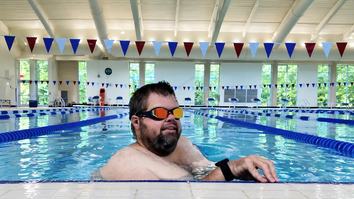Stephen Vinson wearing SollaWave smart swim goggles in an indoor swimming pool