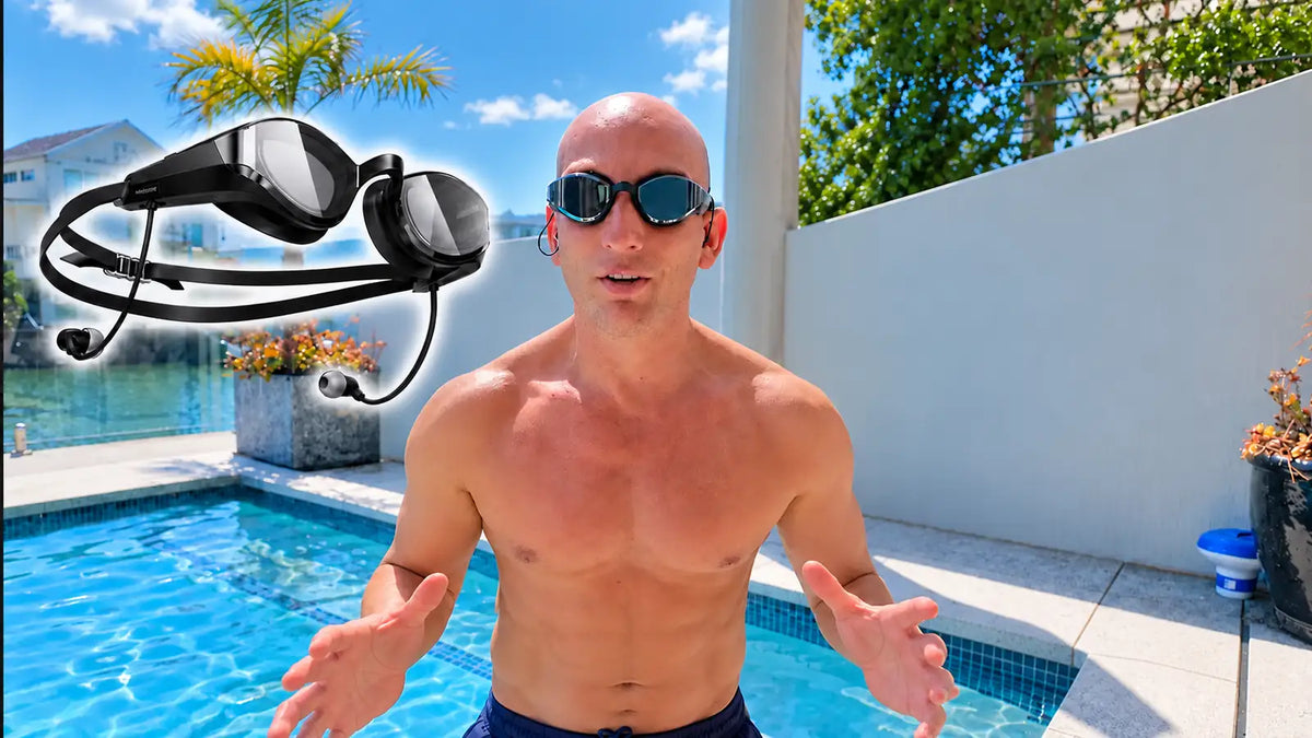 Andrew Hough wearing SollaWave smart swim goggles beside a swimming pool