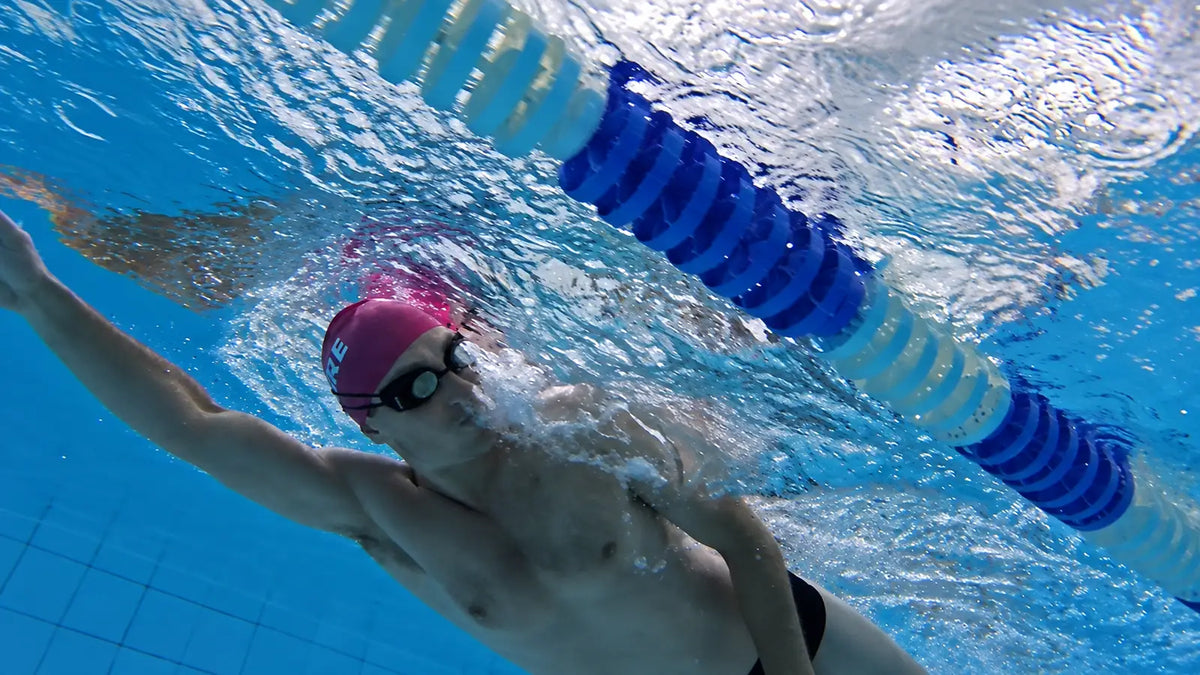 Triathlete training in a pool while wearing HoloSwim 2S smart swim goggles