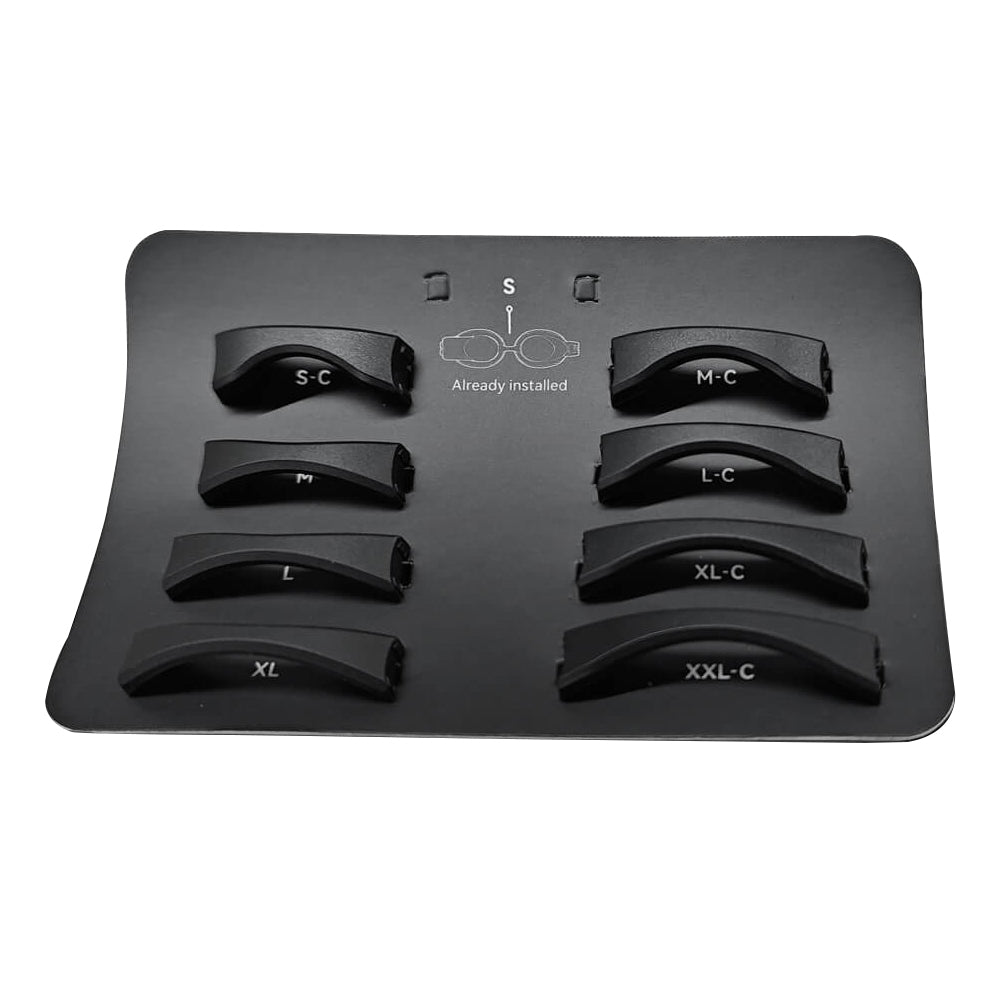 A black tray displaying seven curved Holoswim Nose Bridge pieces in black plastic, labeled S-C, M-C, L-C, L, XL-C, XXL-C, plus one marked "Already installed," with a small glasses diagram between them.